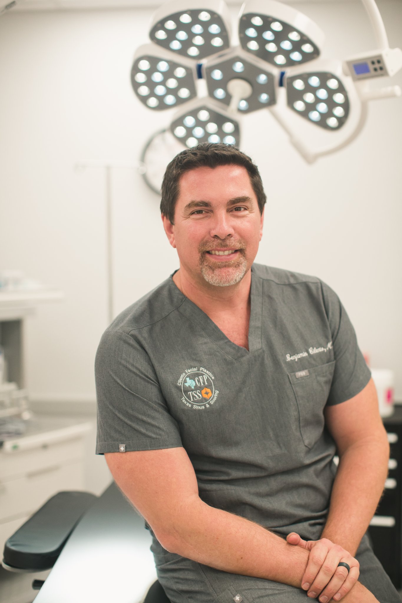 Dr. Ben Cilento, ENT surgeon, smiling in a surgical suite with overhead lighting